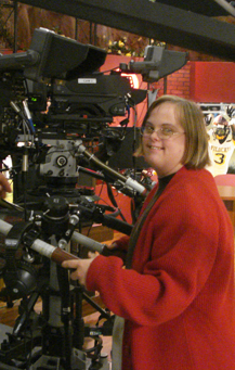 Woman at work with newsroom camera.