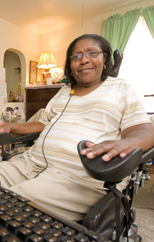 Woman using assistive technology to work on computer.